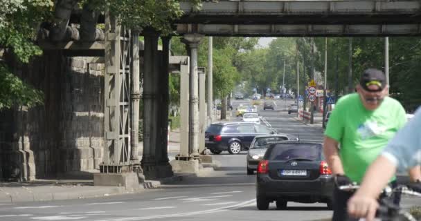 Muži s jízdními koly poblíž auto Road mnoho různých automobilů cesta po zpevněné silnici v Opolu Polsko slunné léto den venku — Stock video