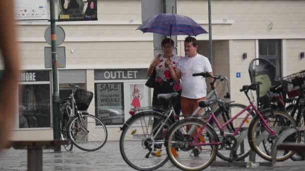 Mężczyzna i kobieta iść razem w deszczu pod jednym parasolem deszczowy dzień lato w Opolu Polska Slow Motion — Wideo stockowe