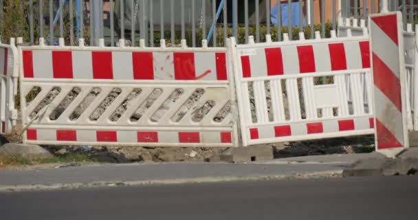 El hombre en las rutas en bicicleta delante del obstáculo rojo-blanco Cerca de seguridad Los coches pasan por carretera pavimentada Reparación de carreteras Día de verano en Opole Polonia — Vídeo de stock