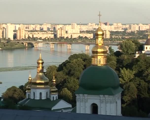 Kiev Cityscape Kievo-Pecherska Lavra Green Cupolas Golden Cupolas Zoom Em Dnieper River Bridge através do rio Árvores Verdes Blue Clear Sky — Vídeo de Stock