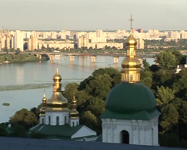 Киево-Печерская Лавра Зеленые купола Золотые купола Зум в Днепре Мост через реку Зеленые деревья Голубое чистое небо — стоковое видео