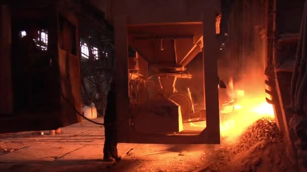Çalışan adam, yüksek fırın portakal yangın turuncu ışık izleme sol alt duvar pencere fabrika ekipmanları oturuyor — Stok video