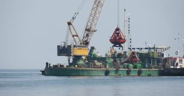 Grande chiatta con gru funziona al mare Giallo-verde barca galleggiare sul mare Aggradazione del suolo Creazione di dighe Groynes Lavori di costruzione al mare Leba Polonia — Video Stock