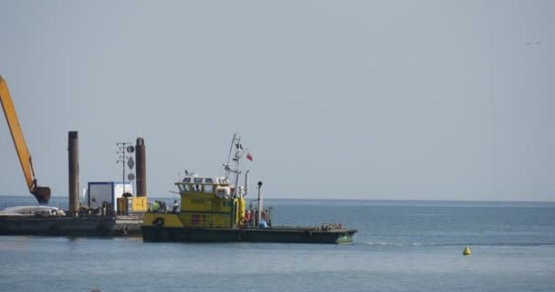 2015 년 10 월 1 일에 확인 함 . Working Excavator On The Barge Aggraese Of Soil Creation Of Dam Groynes Building Works In The Sea People On the Seashore Summer Day Seasveth Leba Poland — 비디오