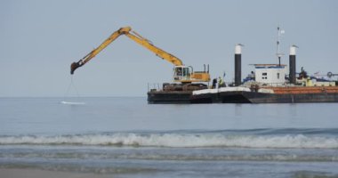 Deniz yaz günü Leba Polonya Deniz Aggradation Barajı Groynes bina toprak yaratılması, mavna iki mavnalar kurulunda sarı Ekskavatör inşaat