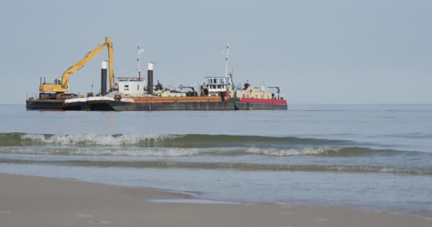 Escavadora de trabalho na placa da barcaça duas barcaças na aggradação do mar da criação de solos de obras de construção de barragens Groynes no dia de verão do mar Leba Poland — Vídeo de Stock