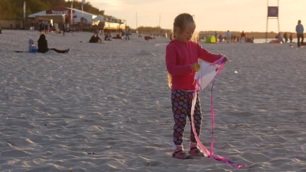 Muchy dziewczyna dziewczynka mała Kite jest kołysząc ludzie rodzin sylwetki są spacery na plaży dzieci grają międzynarodowych Kite Festiwal Łeba Polska — Wideo stockowe