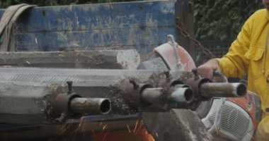 Sarı İş Giyim li Adam İşçisi, Kamyon Uçan Toz Yol Onarımına Yüklenen Makine Turuncu Kıvılcım Tüpleri Öğüterek Tüpleri Taşlıyor