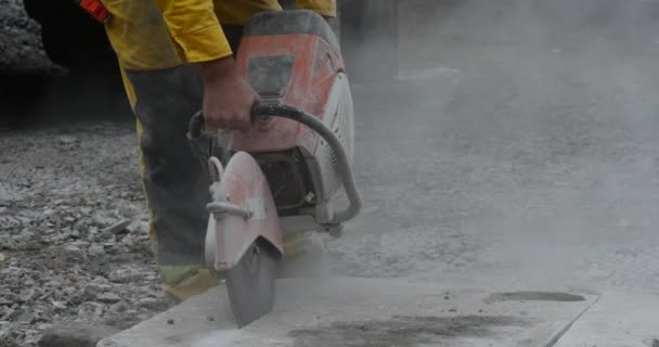 Homem trabalhador em roupas amarelas está moendo os blocos de concreto por máquina de moedura Close Up Flying Dust Road Repair — Vídeo de Stock