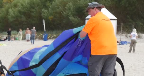 一个人包装空中游泳者 - 人们包装他们的风筝在国际风筝节在勒巴，波兰. — 图库视频影像