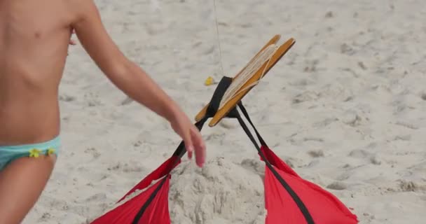 KIds Tocando alrededor de la cuerda de nadador de aire en la playa durante el festival internacional de cometas en Leba, Polonia — Vídeos de Stock