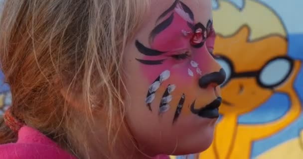 Pintura de rosto Kitty-cat para uma menina em um festival internacional de pipa em Leba, Polônia — Vídeo de Stock