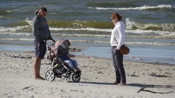 Mensen lopen op het strand in de zon, wandelen langs de kust tijdens het internationale vliegerfestival in Leba, Polen. — Stockvideo