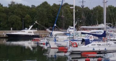 Gemide İnsanlar ile Siyah Yelkenli Liman İnsanlar Dışarı Yüzer Rıhtım Yatlar Üzerinde Yürüyüş Yat Club Port Sakin Su Bulutlu Gökyüzü Sunset Laid Up vardır