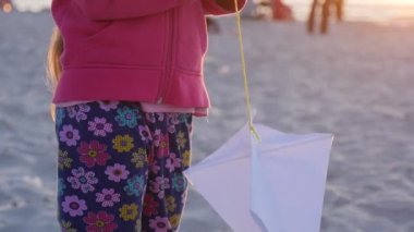 Akşam - yürüyüş ya da Uluslararası Uçurtma Şenliği Leba, Polonya sırasında sahilde oturmuş insanlar iskambil ile bir küçük uçurtma bir kız olduğunu.