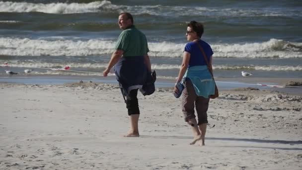 Een paar Walking Barefoot - mensen wandelen op het strand op de internationale kite festival in Łeba, Polen. — Stockvideo