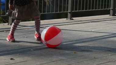 Uzun Adil Saçlar ile Little Girl Renkli Ball Beats Ball Girl ile Futbol Oynuyor Arka Plan Güneşli Gününde Park Ağaçlar Çit Gülümsüyor