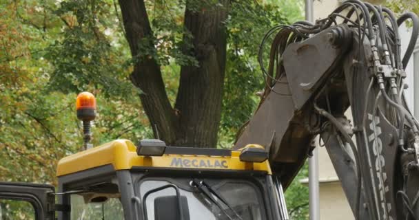 Żółty koparka Flasher dachowy na dachu miarki Dach z bliska Zielone drzewa Brukując drogę klockami Naprawa ryku Polska Opole — Wideo stockowe