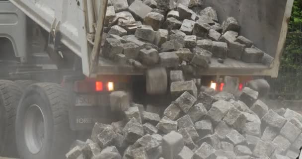 Camión descarga los bloques Camión de camiones transporta los bloques Reparación de carreteras pavimentando la carretera con bloques Árboles rodados con arbustos verdes Polietilen City Street — Vídeos de Stock