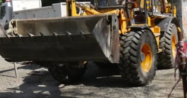 Sarı Kazıcı Dönüyor ve Yol Tamir Ediyor Sokak Kadınları Bebek Bebek Bebek Arabası Tabelasıyla Yürüyor Kırmızı ve Beyaz Güvenlik Çitleri Güneşli Gün Ağaçları