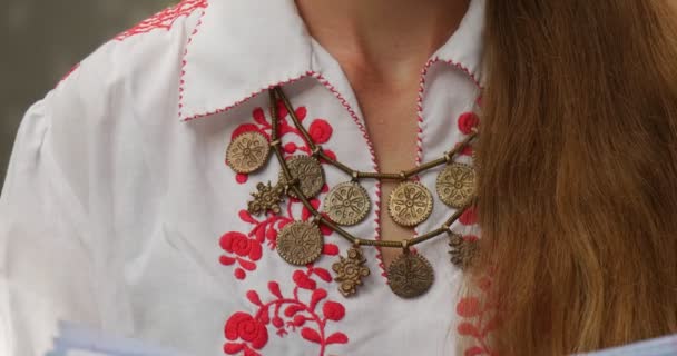 Woman With Long Hair In Emroidered White Shirt Reads The Book Red Patern On The Woman's Shirt Necklace Close View John Paul II Municipal Public Library — Stock Video