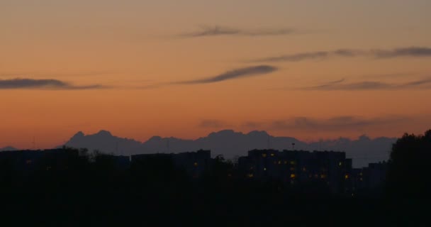 住宅の住宅建物シルエット窓が点灯の川の土手の木シルエット ピンクの空の夕焼けの雲の浮かぶ夜のサンセット — ストック動画