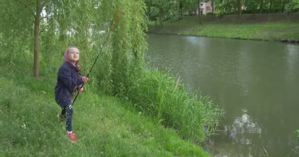 Recht sluit weergave kind meisje op de oever van het meer gaat vissen — Stockvideo