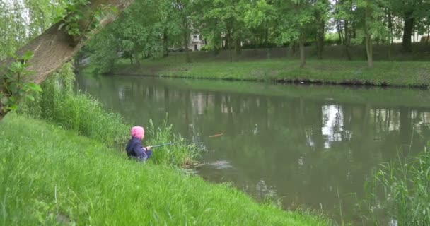 Správné vzdálenosti pohledu dítě dívka na břehu jezera vede rybaření — Stock video