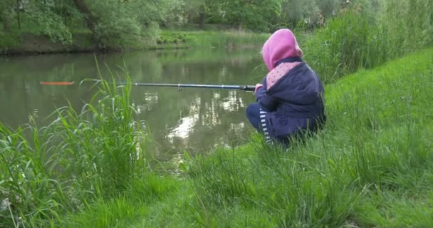 Вид збоку зліва Дівчинка на березі озера йде Риболовля — стокове відео