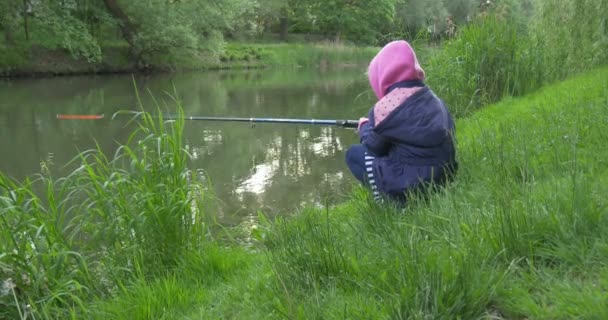 Side view from the left Child Girl on The Lakeside Goes Fishing — Stock Footage Side view from the left Child Girl on The Lakeside Goes Fishing Royalty Free Stock Video