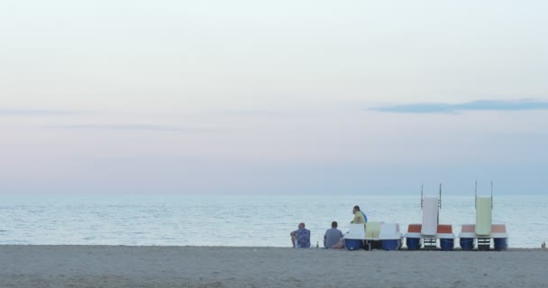 Ludzie, trzej mężczyźni mają odpocząć na wybrzeżu, linia brzegowa, piaszczysta plaża, po dniu roboczym, praca na katamaranie, woda Motocycle — Wideo stockowe