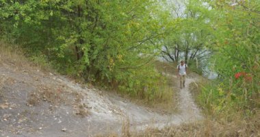 Sırt Çantası ile Beyaz T-Shirt Man Turist Man Green Hill Park Orman Yeşil Buches Yeşil Ağaçlar Erken Sonbahar üzerinde Footpath tarafından Tırmanıyor