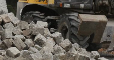 Sarı Ekskavatör kapatmak Scoor kapmak kadar yolun Polietilen ile silindir blokları ağaçları ile kaldırım blok yol onarım blok yığını