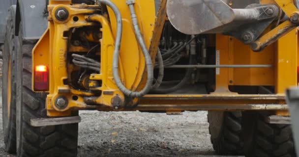 Yellow Excavator is Moving Excavator Close Up Cars Have Passed by Camera Excavator Scoop Close Up Group of Workers Men Road Repair Blocks Outdoors Sity — Wideo stockowe