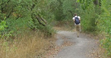 Sırt Çantası ile Beyaz T-Shirt Man Turist Man Green Hill Overgrown Hill Yeşil Buches Yeşil Ağaçlar Üzerinde Footpath tarafından Aşağı Çalışıyor