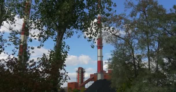 Umweltverschmutzung der Umwelt Wärmekraftwerk Opole poland energetyka cieplna opolszczyzny rote Gebäude grüne Bäume Blick durch die Bäume — Stockvideo