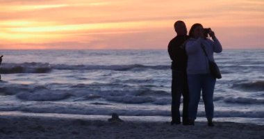 Orta yaşlı çift video insanlar aileler çocukları götürecek uçan uçurtma uçurtma günbatımı Uçurtma Festivali taşıyan Beach insan tarafından yürüme, iyiye gidiyor