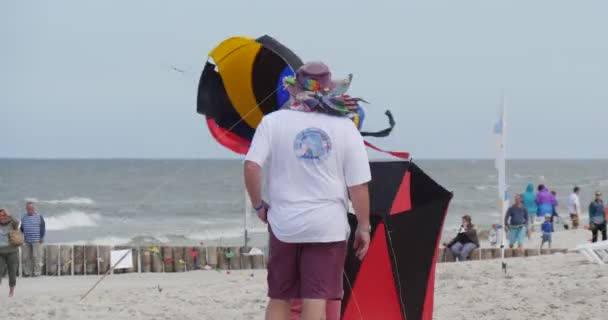 Koniska luft simmare - människor utarbetar sina drakar och luft simmare eller flyger dem på den internationella kite festivalen i Łeba, Poland. — Stockvideo