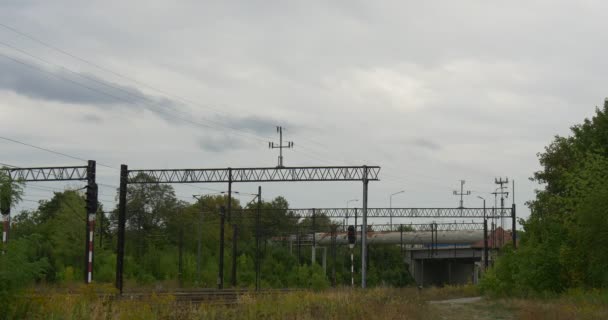 Rede de contatos de ferrovia elétrica Rede de contatos suporta trilhas ferroviárias Árvores verdes Dia de outono nublado — Vídeo de Stock