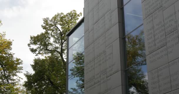 Edificio de la Biblioteca Pública Municipal Juan Pablo II en Opole Polonia Paredes grises Ventanas de vidrio Árboles verdes al aire libre — Vídeo de stock