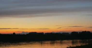 Nehir banka binaları, tam tersi banka binaları ufuk sarı gökyüzü Twilights günbatımı dalgalanan su birikintisi ağaç üzerinde yansıma siluetleri