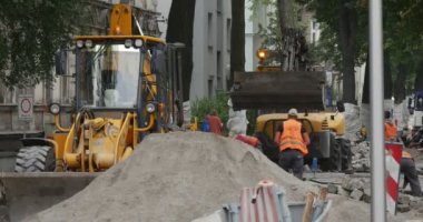 İşçilerin iş giysisi iki sarı Ekskavatör Flasher çatı sürücü yolda kaldırım blok Granit toz Cityscape Street yığını taşıma ile yolun onarmak