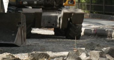 Workers Man in Yellow Workwear at The Street Road Repair Yellow Excavator is Moving Scoop Close Up Machine is Moving Back Running Man