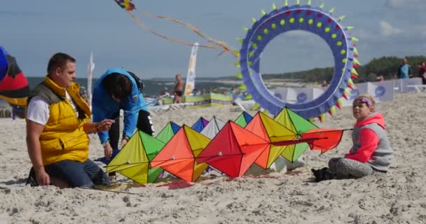 Lidé, kteří připravují draka zajímavé stavby-lidé, kteří připravují své kity na mezinárodní festival draků v Lebě, Polsko. — Stock video
