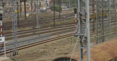 Sarı lokomotif olduğu hareketli demiryolu yürüyen insanlar tel Towers teller istasyonu tarafından arka plan arabalar yolun şehir sokak bulutlu tarafından geçiyor