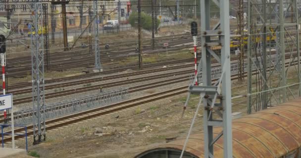 Gele locomotief is Moving door Railroad Walking People draad torens draden Station op achtergrond auto's zijn de weg City Street bewolkt langs — Stockvideo