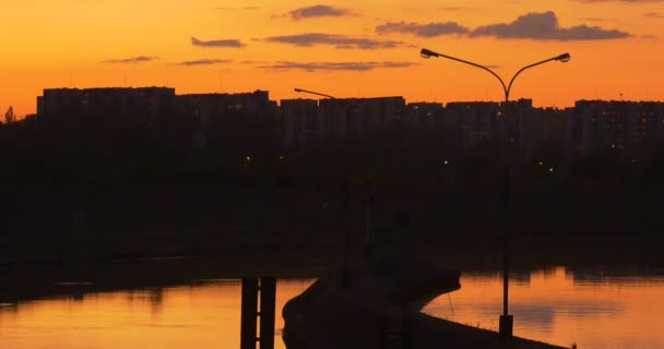 Dam na rzece Zamknij widok dam w mieście Dike wspiera Smooth Woda Reflection domy mieszkalne jasnożółty zachód słońca drzewa sylwetki — Wideo stockowe