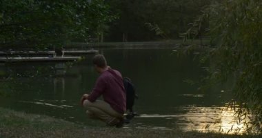 Man River Lake Bank Man Man Tooks Onun Sırt Çantası Oturur Ayağa Kalktı ve River Lake Uzak Şezlong İki Ahşap İskeleler Yürüyüş