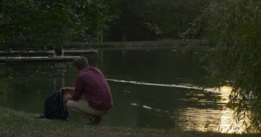 Man River Lake Bank Oturuyor Sırt Çantası Wild Duck Mallard Bir Şey Arama Onun Sırt Çantası Aldı Su Yüzeyinde İz Yüzme