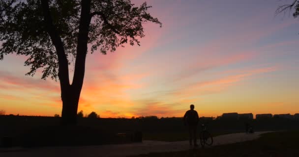 Homme avec sac à dos vient en vélo Silhouette de l'homme descendu de la marche à vélo à la grande pierre Escalade à la pierre debout Mettre le sac à dos — Video